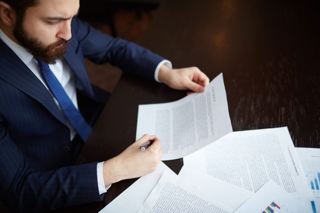 Imagem de uma pessoa analisando um contrato - Gestor e Fiscal de Contratos